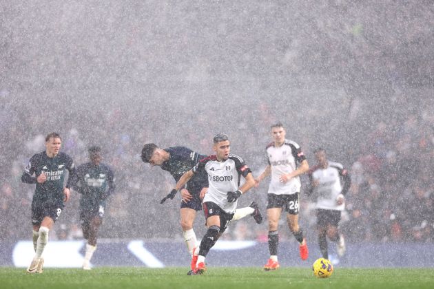Andreas Pereira of Fulham runs with the ball in a rain storm during the Premier League match between Fulham FC and Arsenal FC