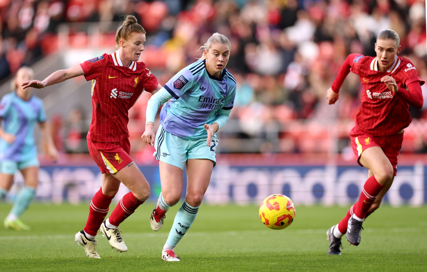 Alessia Russo of Arsenal runs with the ball whilst under pressure from Jasmine Matthews and Jenna Clark of Liverpool